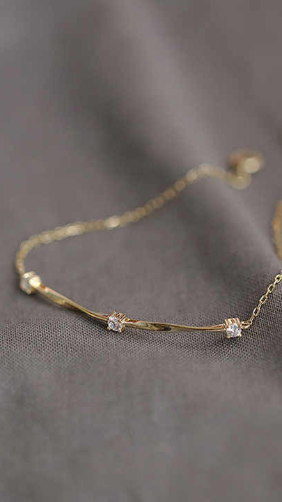 Gold Bracelet with Twist Bar Design and Three Cubic Zirconia Accents